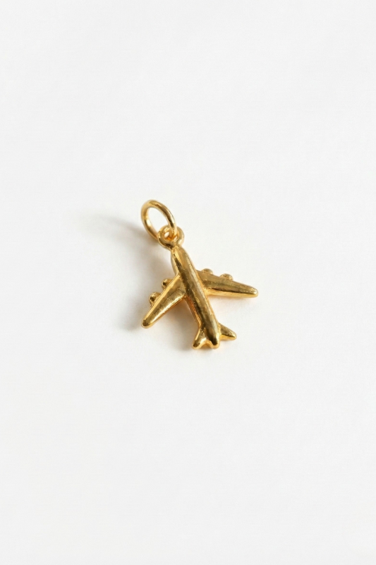 Gold airplane pendant on a white background