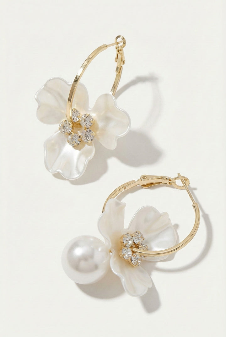 Pair of floral earrings with pearls and gold accents on a white background