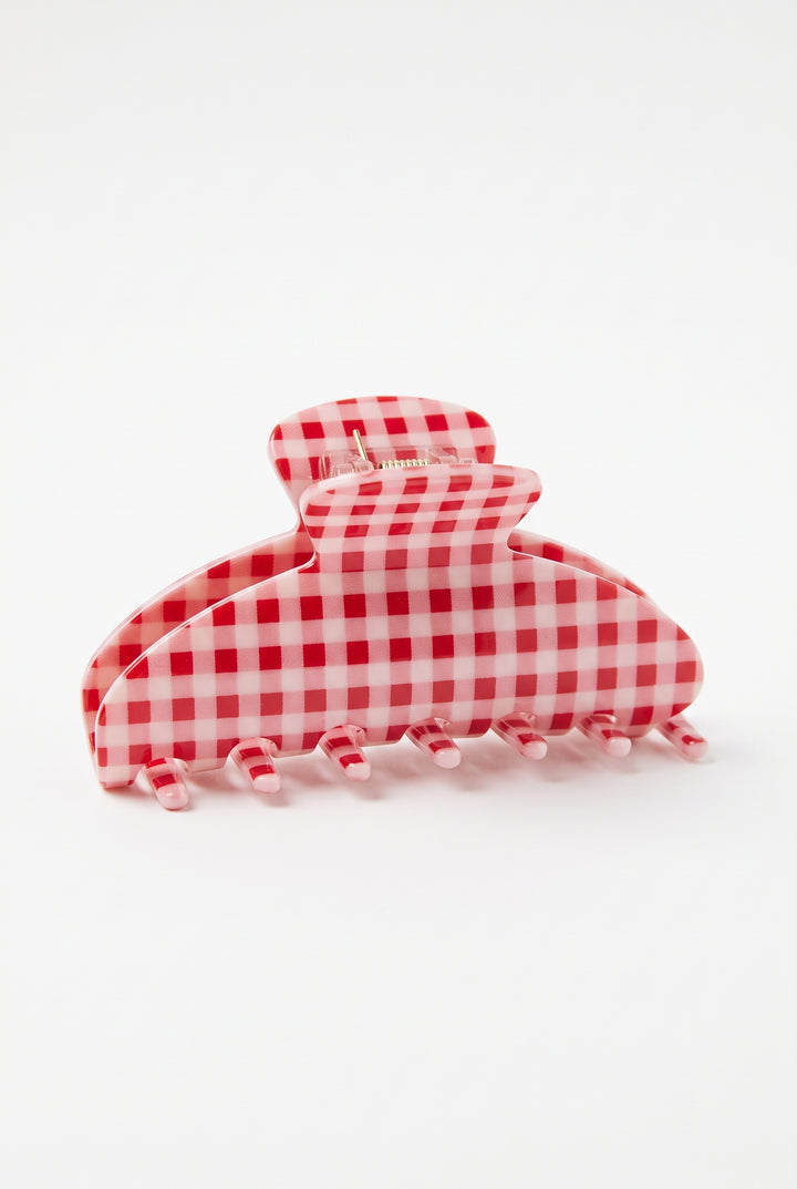 A large claw hair clip in a red and white gingham checkered pattern, photographed on a seamless white background.